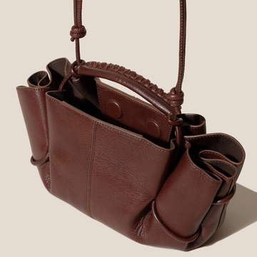 Rich Vintage Chocolate Brown Curved Gathered Side Panel Carry Bag With Intricate Woven Top Grip And Thin Knotted Draw Straps
